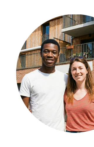 Couple souriant devant un immeuble
